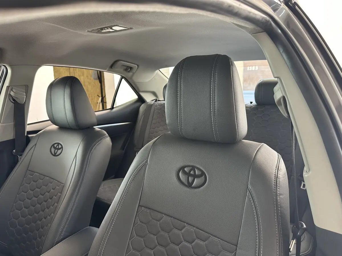 Салон Toyota Corolla XI (E170) в преміальних сірих чохлах VIP Elite з антари з візерунком сота та вишивкою логотипа.