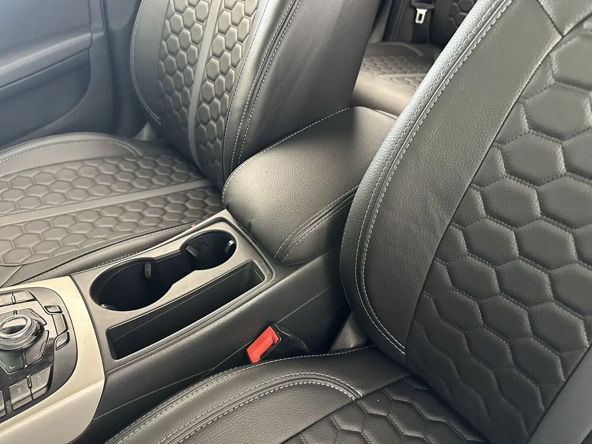 Салон Audi A4 IV (B8) з встановленими чорними чохлами Eco Sport з екошкіри, сірою центральною смугою та логотипом Audi.