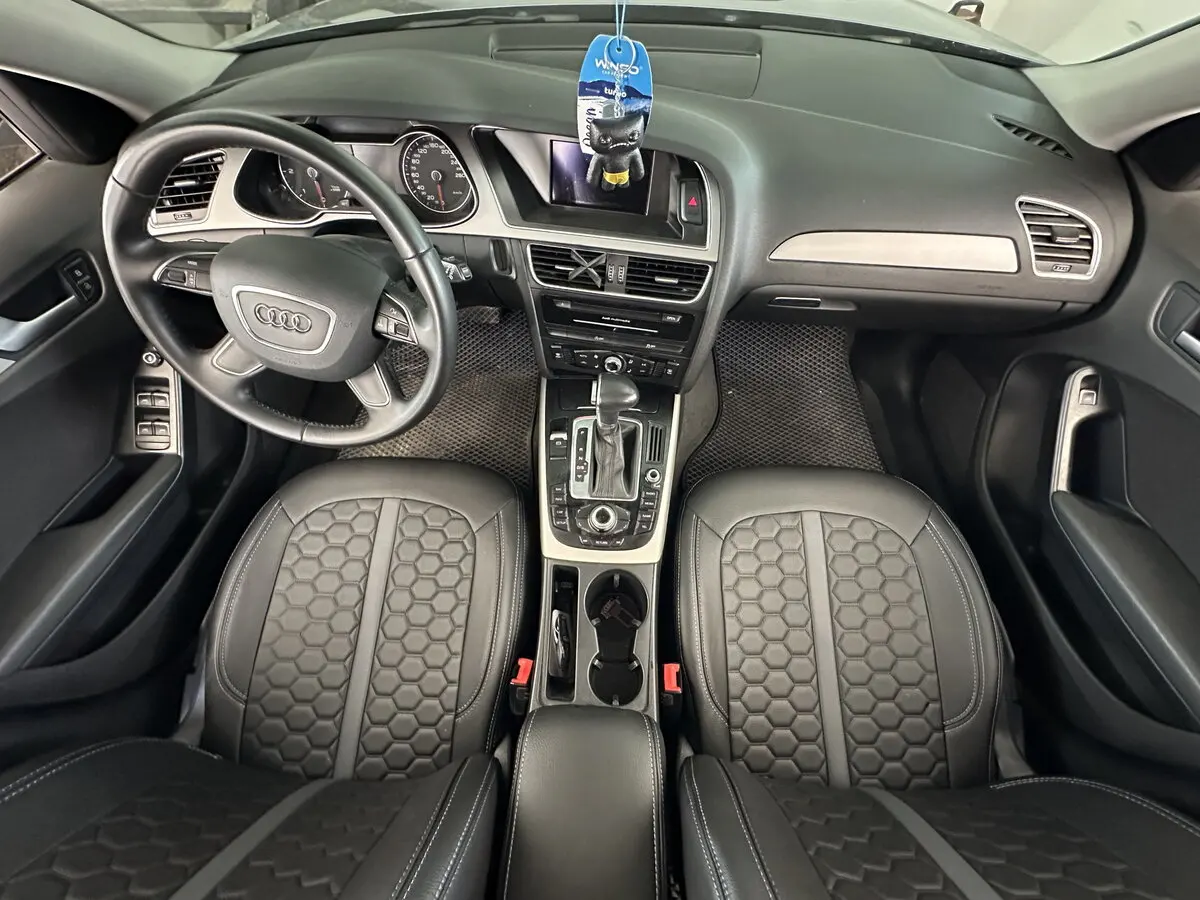 Салон Audi A4 IV (B8) з встановленими чорними чохлами Eco Sport з екошкіри, сірою центральною смугою та логотипом Audi.