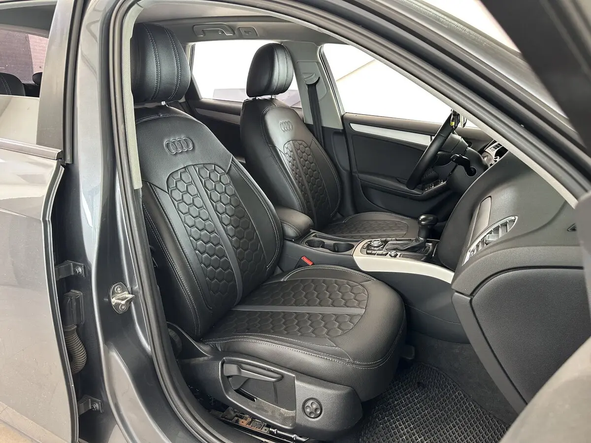 Салон Audi A4 IV (B8) з встановленими чорними чохлами Eco Sport з екошкіри, сірою центральною смугою та логотипом Audi.