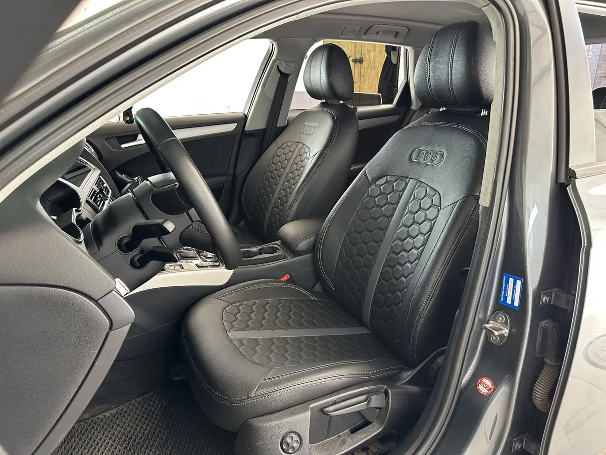 Салон Audi A4 IV (B8) з встановленими чорними чохлами Eco Sport з екошкіри, сірою центральною смугою та логотипом Audi.